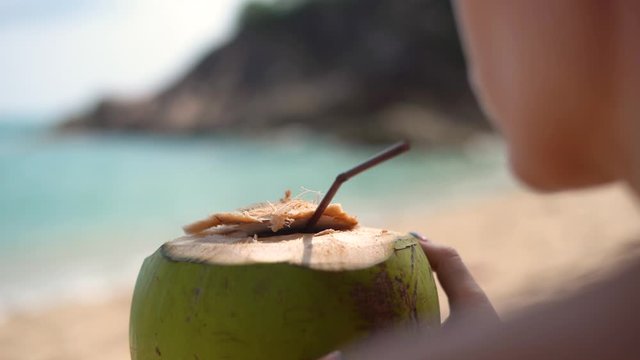 Girl relaxing drinking healthy fresh coconut water on tropical suntan holiday on a Phangan. 