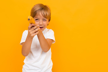 Cute little boy in t-shirt and trousers isolated on yellow background