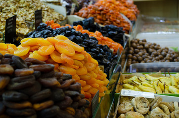 Dried dried apricots, raisins and persimmons closeup. Colorful dried fruits stall background.