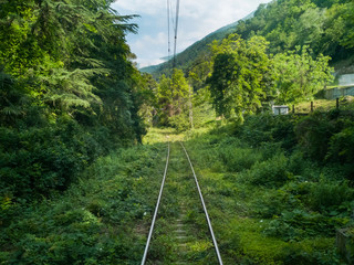 Mountain railway in summer, the greenery disappearing into the distance in the Caucasus, at the railway station