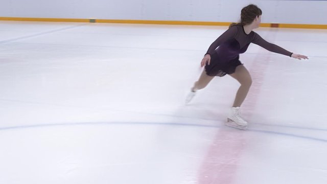 Teenage Ice Skater Skating Backwards And Spinning