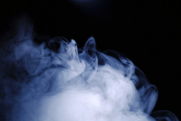 Aromatherapy. Essential oil aroma diffuser humidifier diffusing water articles in the air. Electric ultrasonic device emitting atomized water droplets against black background with copy space.