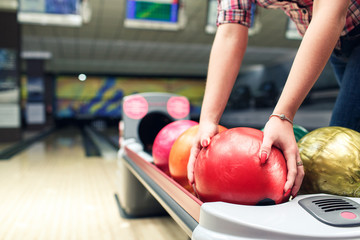 close-up hands of girls take bowling ball