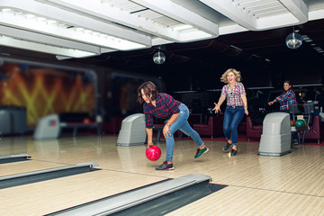 beautiful girl plays bowling in bowling club