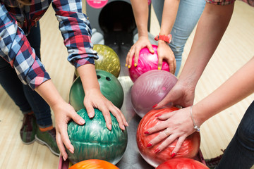 female hands take bowling balls