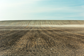 View of a very large plowed field and sky