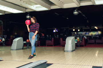 beautiful girl plays bowling in bowling club