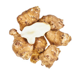 half of tuber on pile of ripe jerusalem artichokes