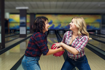 two funny girls snatch bowling ball from each other