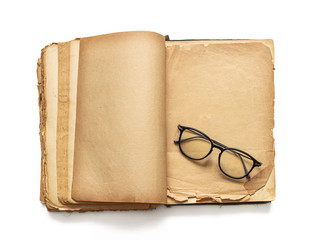 An open old book and glasses, on yellowed pages