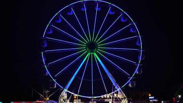 View of amusement park at night. Colorful ferris wheel in luna park