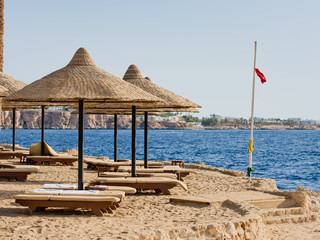 Beach in the early morning with umbrellas and sunbeds.