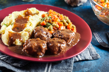 Roasted meatballs in dark sauce with mashed potatoes