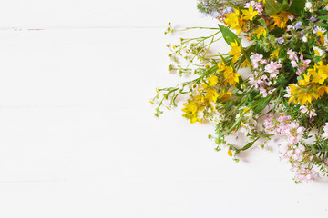 wild flowers with straw hat on white background. Top view, flat lay. copy space