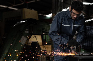 Good factory technicians are grinding iron at the shop causing sparks.