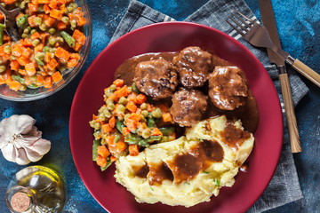 Roasted meatballs in dark sauce with mashed potatoes