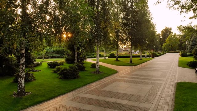 Cobblestone pathway in a park. Morning sunshine through park trees.