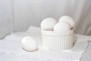 white eggs in a white cup on a white background
