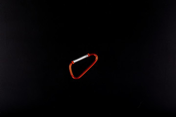 Metal carabiner isolated on a black background in full size.