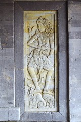 Carved stone relief decorative panel on ancient stone structure in Bali Indonesia