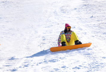 Fototapeta na wymiar Young woman snowboarding on hill. Winter vacation