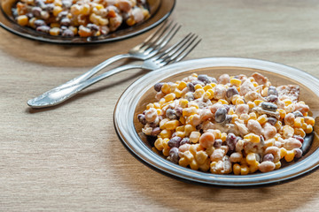 salad of red and white beans and sweet corn on glass plates close up