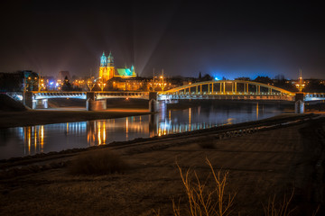 Fototapeta na wymiar Katedra Poznańska i Most Św. Rocha z odbiciem lustrzanym w Warcie