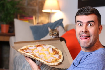 Enthusiastic man enjoying pizza at home 