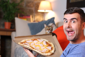 Enthusiastic man enjoying pizza at home 