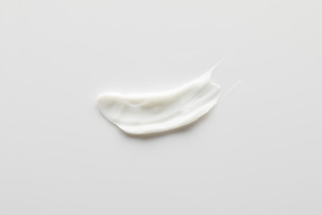 Top view of cosmetic cream brushstroke on grey background