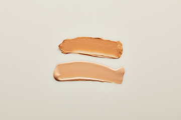 Top view of beige tone cream brushstrokes on grey background