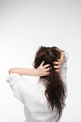 Fototapeta premium back view of young woman touching wet clean hair isolated on white