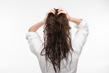 back view of young woman touching clean long hair isolated on white