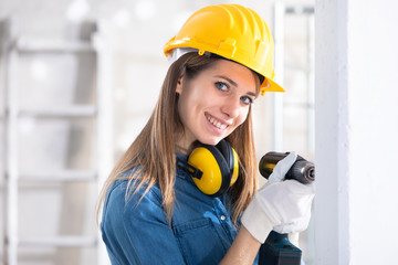 Attractive Female Builder drilling a hole