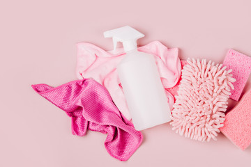 Detergents and cleaning accessories  in pink color.  Cleaning service concept. Flat lay, Top view.