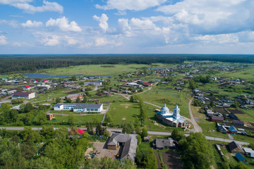 Aerial view of church and school in Lipovskoe village. A lot of grass and trees. Russia, Sverdlovsk region