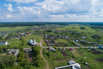 Aerial view of church in Lipovskoe village. A lot of grass and trees. Russia, Sverdlovsk region