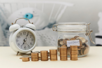Coin sapling and alarm clock in the piggy bank