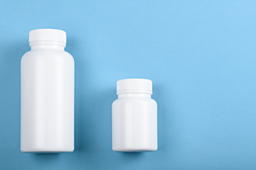 two white plastic bottles on blue background
