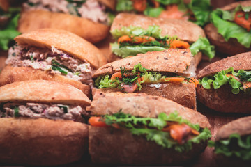 Beautifully decorated catering banquet table with different food snacks and appetizers with sandwich, on corporate christmas birthday kids party event or wedding celebration