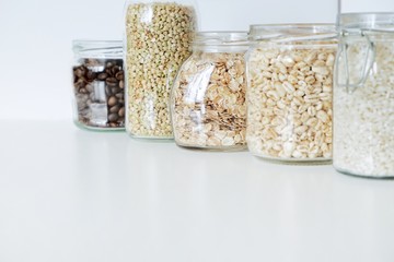 Various raw cereals, grains in glass jars. The concept of zero waste, food storage in the kitchen,...