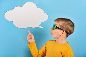 The boy shows on a blank poster for the inscription in the form of a cloud on a blue background.