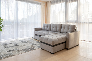 Modern interior with big sofa and a large windows