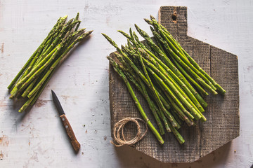 asparagus on a cut board on an old white background