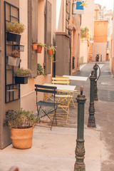 Empty coffee terrace with tables and chairs on South of France. Table and chairs in front of a cafe in Italy or France. Provence style