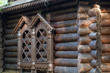 Facade of a dark log house. Imitation window