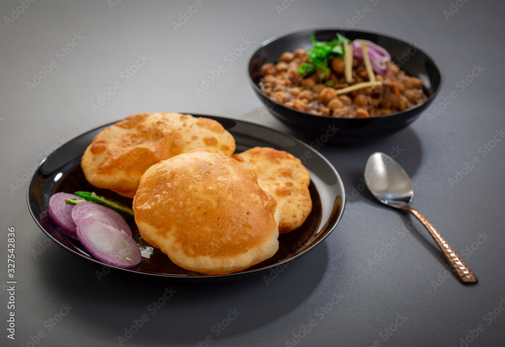 Wall mural choley bhature is a dish originated initially in the northern part of the Indian subcontinent.  It is a combination of chana masala and bhatura, a fried bread made from maida.