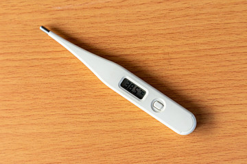 A digital thermometer on a wooden table.