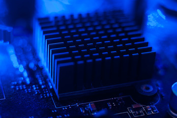 Motherboard radiator with blue backlight. Electronics in neon light.Motherboard components
