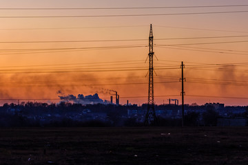 View on smoke pipes of the factory at sunset